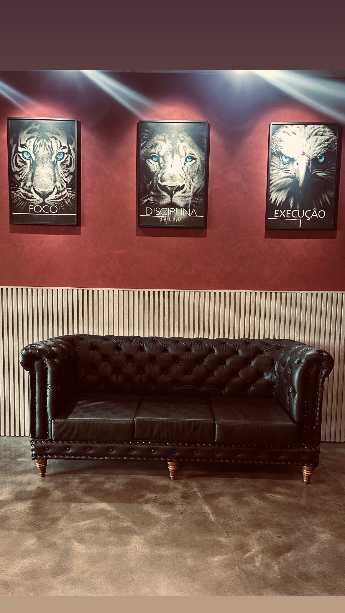 Sala de espera com sofá Chesterfield e quadros FOCO · DISCIPLINA · EXECUÇÃO